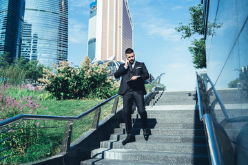 Businessman descending stairs in summer in city