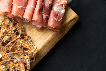 close up of prosciutto and crackers on a charcuterie meat board