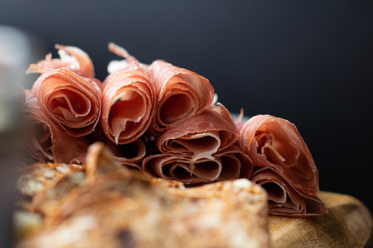close up of prosciutto and crackers on a charcuterie meat board