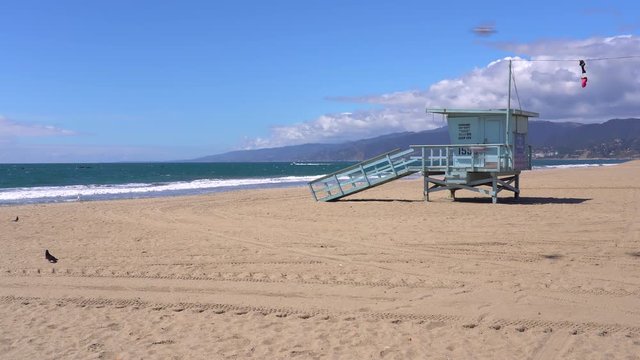 A single lifeguard tower stands alone on the Santa Monica Beach on a sunny day due to California's COVID-19 (Coronavirus) laws and regulations.