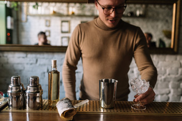 Bartender preparing cocktail based on gin, birch juice and essential oil of frankincense.