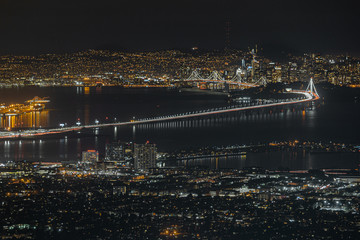 Fototapeta premium Bay Area California night view from Grizzly Peak. San Francisco, Oakland, Alameda, Berkeley, Bay Bridge and Sutro Tower. City skyline long exposure with water reflections.