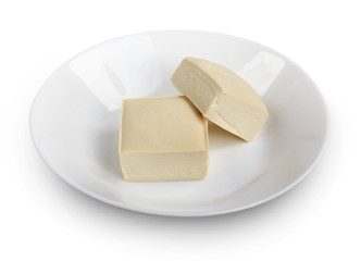 Two blocks of white tofu with plate isolated on white.