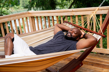 Man relaxing in hammock on deck of home