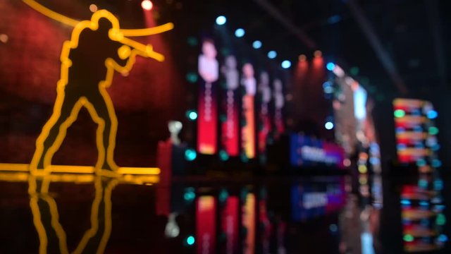 Esports event blurred background. Main stage, lighting, illumination, big screens with game moments.