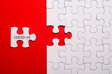 White puzzle on blue background with word COVID-19. Coronavirus pandemic prevention social distance and self-quarantine.