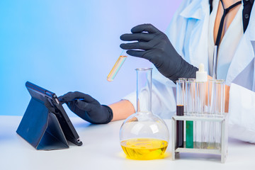 Lab technician writes data to the tablet. The girl enters the analysis data into the computer....
