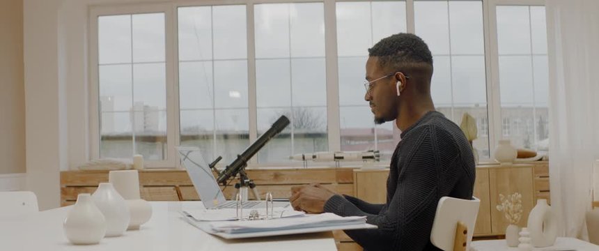 African American male remote working from home, having work confrence video call. Stay home, quarantine remote work. ARRI Alexa Mini with 2x Anamorphic lens