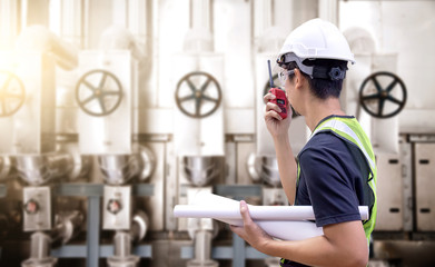 Engineering personnel in standard safety uniform work in gas turbine power plants during sunset or morning.