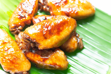 Chicken wings with cola sauce on green background