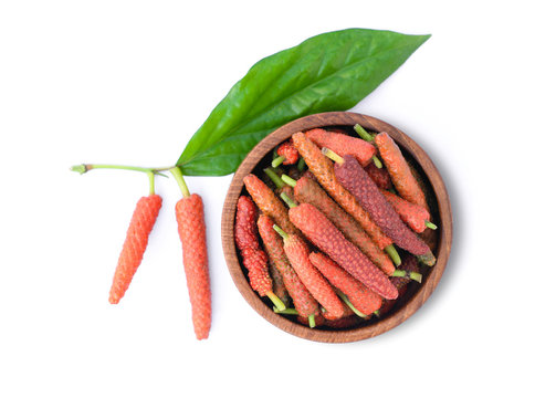 Fresh red ripe Idian long pepper ( Piper Longum ,Piper retrofractum ) in wooden bowl isolated on white background . 