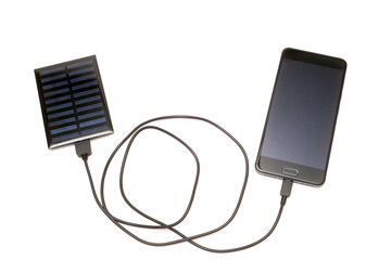 太陽光パネルから充電中のスマートフォン