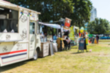 Food trucks and people at a street food market festival, blurred on purpose
