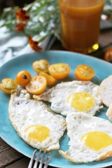 sunny breakfast life style, fried eggs and yellow cherry tomatoes. on a blue plate. yellow and blue