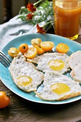 sunny breakfast life style, fried eggs and yellow cherry tomatoes. on a blue plate. yellow and blue