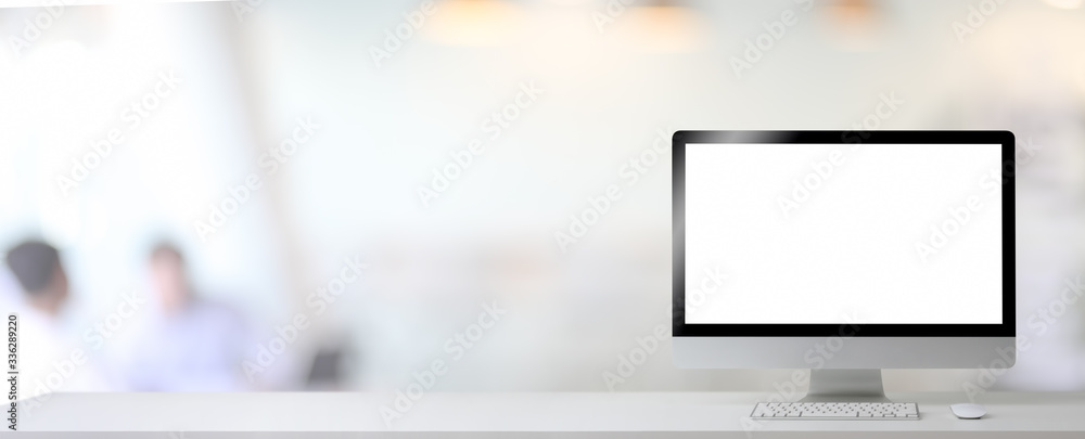 Poster close up view of blank screen computer and copy space on white table in blurred office room backgrou