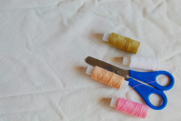 sewing threads of different colors and scissors