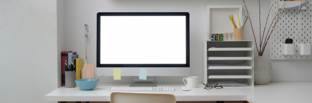 Close up view of minimal office desk with blank screen computer on white table