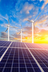 Solar panels with wind turbines in the setting sun,green energy.