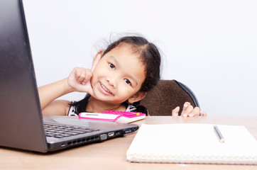 Asian baby girl portrait with sitting on computer desk for working from home concept