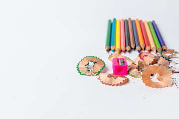 Sharpener with color pencils on white background.