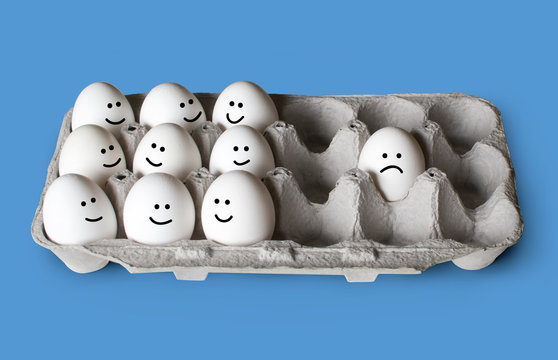White eggs in a carton, one separated from the group, isolated concept