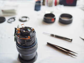 Technician disassembling lens, Disassembly and repair of lens camera by Technician Engineer, Specialist of the center for repair of lens, Selective focus.