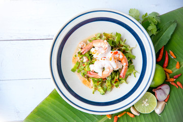 Wing Bean or Betel Nuts Spicy Salad  ingredient coconut milk, roasted chili paste, toasted coconut, tamarind, palm sugar and peanuts on white dish for Thai food style, wood table as a background.