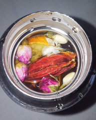 Flowers and dried fruits in a thermos with tea. Close up.