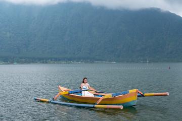 a cute asian girl paddle the boat at the big lake