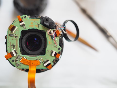 Technician disassembling lens, Disassembly and repair of lens camera by Technician Engineer, Specialist of the center for repair of lens, Selective focus.