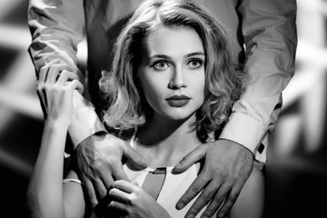 Male hands hugging attractive smiling blonde, black and white photo