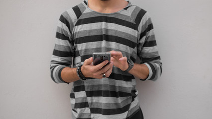 joven utilizando su celular con las manos 