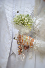 bride's hand holding a flower bouquet