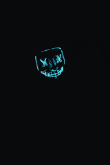 Illuminated Scary Facemask in a Dark Black Background