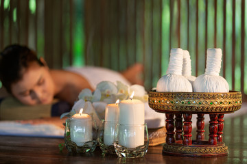 Thai Massage of asian woman in spa room. Beautiful young woman having massage with herbal compress balls in therapy spa salon.