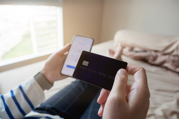 Online shopping payment,Woman's hands holding a smart phone and credit card and for online shopping at home