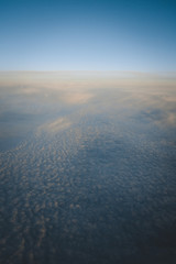 view from the window of the plane with clouds and sunset colours