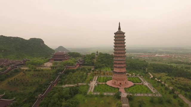 Aerial Approach Shot of Xa Loi stupa to Laughing Buddha statue at Bai Dinh Temple Spiritual and Culture Complex in Ninh Binh Vietnam, the largest spiritual tourist place in Vietnam