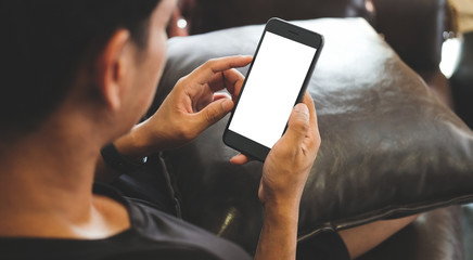 Cropped shot view of man hands holding smart phone with blank copy space screen for your text message or information content, female reading text message on cell telephone during in urban setting. 
