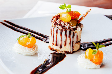 Creamy cheesecake with with syrup glazed fruits and whipped cream