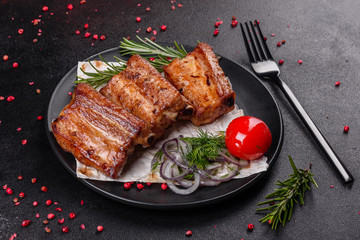 Fried ribs with rosemary, onion, sauce on a concrete background