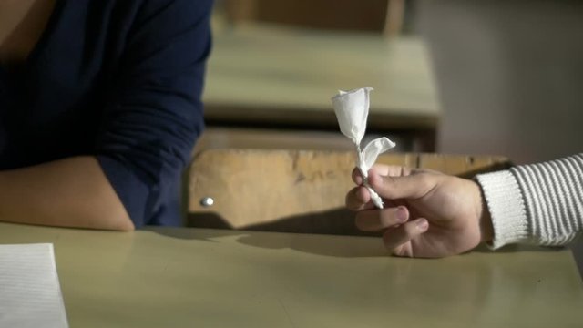 High school boy giving a present to girlfriend in the class