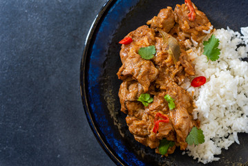 Chicken tikka masala curry with steamed rice, dark background, flat lay, close up, copy space