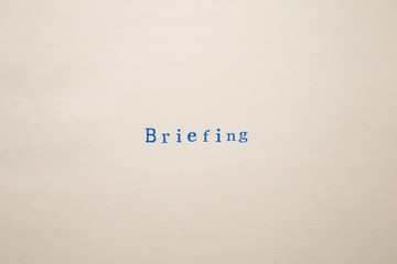 a BRIEFING word stamped on a piece of paper.