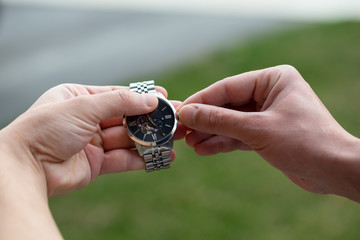Hand adjusting analogue watch; concept for time.