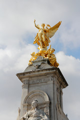 Gilded Winged Victory at the top of the Victoria Memorial in front of Buckingham Palace in a sunny...