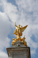Fototapeta na wymiar Gilded Winged Victory at the top of the Victoria Memorial in front of Buckingham Palace in a sunny day, London, UK