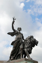 Fototapeta premium Peace, one of four bronze statues around the Victoria Memorial in front of Buckingham Palace in a sunny day, London, UK