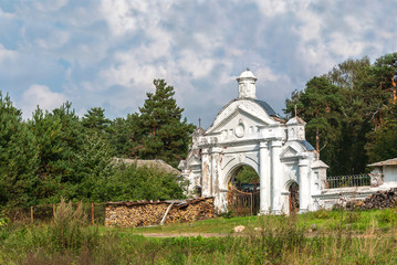 Fototapeta na wymiar Antique entrance to the territory of the rural orthodox church and cemetery